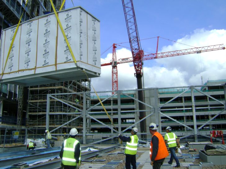 Lifting air conditioning units on a congested construction site in manchester, risks include working in close vicinity of other site cranes.